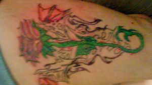 Well is a bad picture but I love this tat my best friend designed it. Its tribal dragon wings in the background and a rose blooming On top. You know it means the world to me cause he made it just for me and im so happy I was able to have it tatted on me. God Rest his soul. Love you Jerry Coffman aka "JerrBear" Thank you Steve Rank for inking it on me!