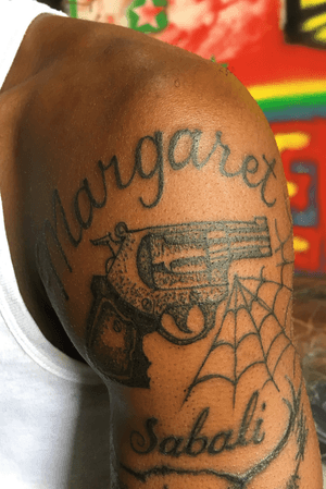 Letteing and pistol tattoo