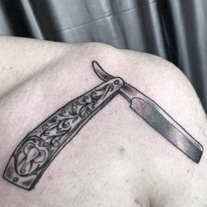 An old cutthroat razor with a small elephant and some floral patterns 