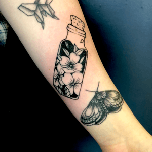 Healed moth fresh bottle with flowers on forearm