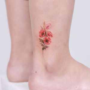 Ankle tattoo by Donghwa Tattoo #DonghwaTattoo #ankletattoo #ankle #leg #smalltattoo #anklet #flowers #floral #color #realism #realistic #small