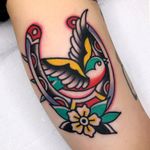 Bird tattoo by Redlip Tattooer #Redliptattooer #birdtattoos #birdtattoo #bird #feathers #wings #flying #tattooidea #traditional #horseshoe #flower #swallow