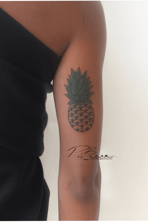 Get a vibrant illustrative pineapple tattoo on your upper arm by talented artist Patrick Bates. Embrace the tropical vibes!
