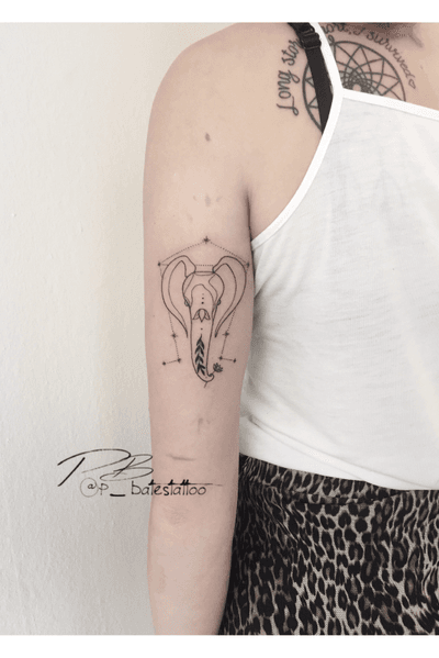 Fine line and illustrative style upper arm tattoo by Patrick Bates, featuring a geometric elephant design with intricate patterns.