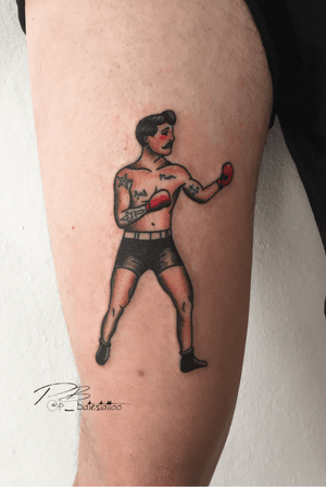 Get a knockout traditional tattoo on your upper arm featuring a boxer with gloves by artist Patrick Bates.