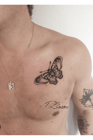 Experience the beauty of Patrick Bates' blackwork butterfly tattoo on your chest. A stunning and bold piece of art.