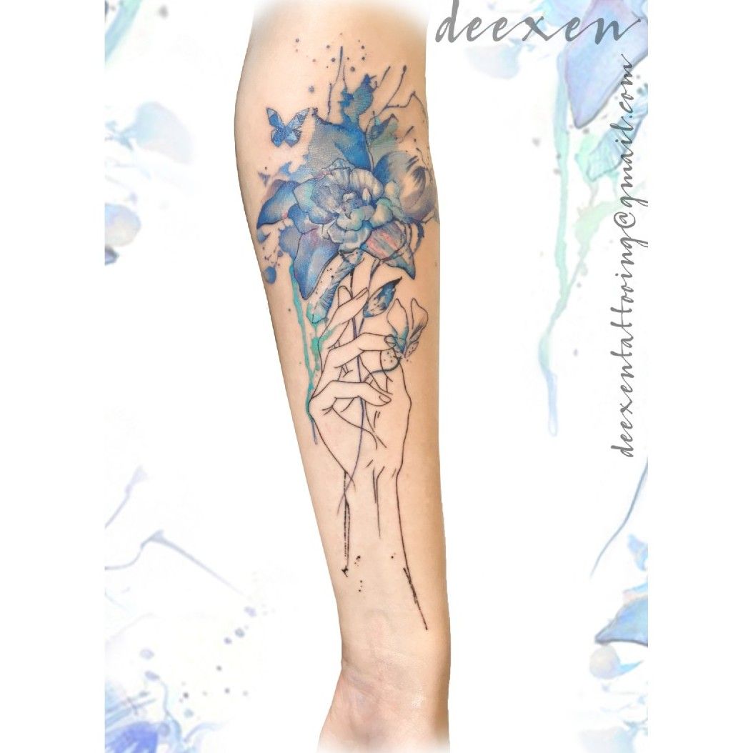 Watercolor blooming flower tattoo on the tricep