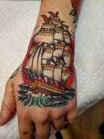 Traditional ship at sea with sunset hand tattoo