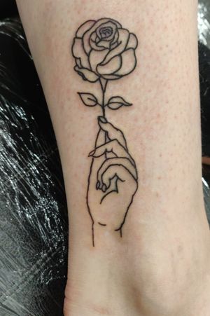 Outline hand holding a rose. 