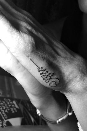 Tatuaje de Unalome en el proximal de la mano