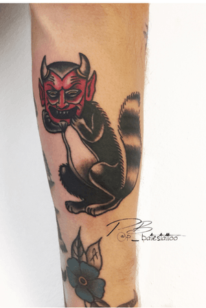Get a unique forearm tattoo by artist Patrick Bates featuring a cat with devil horns in traditional illustrative style.