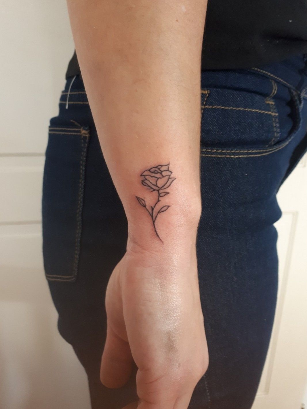 Tiny sprout tattoo on the back of the left arm