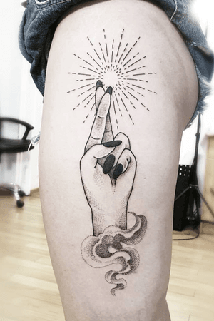 Traditional/realistic illustration of a hand with fingers crossed large in black on the Side of a clients thigh. Used single needle shading for stick and poke like soft shading.