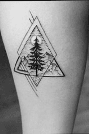 Geometric diamond inside a triangle design with a nature/pine tree and moon scene inside on the outside of a clients thigh in black and white.