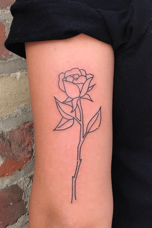 Traditional Black outline of a rose on back of upper arm.
