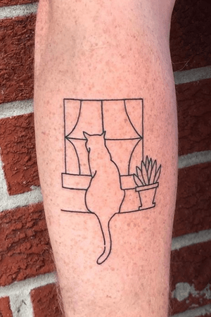 Outline of cat looking out window in black on forearm.