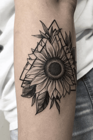 Geometric triangle sunflower design on inner forearm in black realism. 