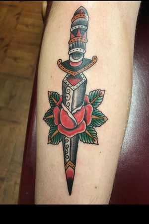 Traditional dagger through a rose.
