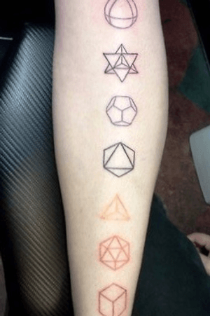 Shin color tattoo of geometric shapes in vertical line down length of leg from knee to ankle.