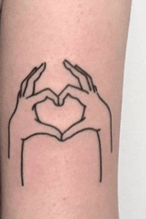 Outline of 2 hands making a heart shape on back of upper arm in black.