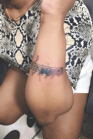 Watercolor music tattoo done by Inktensean 