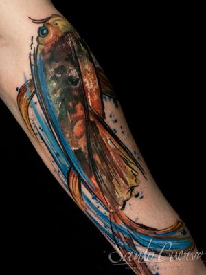 Get a vibrant watercolor tattoo featuring a fish and brush motif by Alex Santo that will make your forearm stand out.