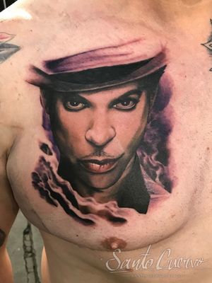 Impressively detailed chest tattoo of a prince in vibrant colors, created by the talented artist Alex Santo. A true masterpiece of realism art.