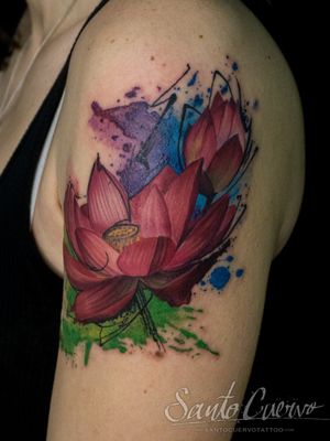 Experience the beauty of a watercolor lotus flower tattoo expertly inked on your upper arm by the talented artist, Alex Santo.