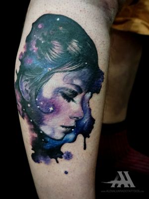 Experience the beauty of the universe with this stunning watercolor tattoo of a celestial woman, created by artist Alex Santo.