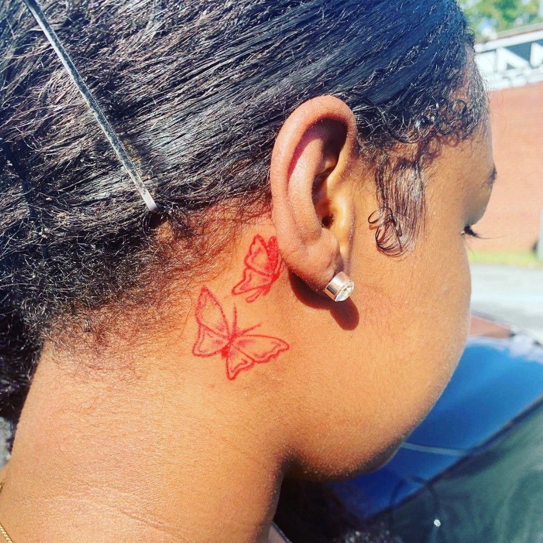 butterfly tattoo behind the left ear