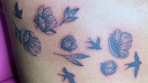 flower and bird tattoo on the ribs