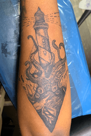 black and grey tattoo of a squid attacking a lighthouse