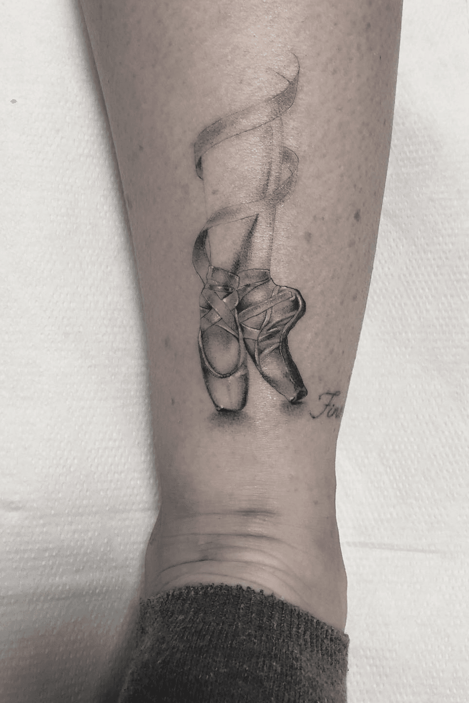 Fine line ballet shoes tattoo on the ankle