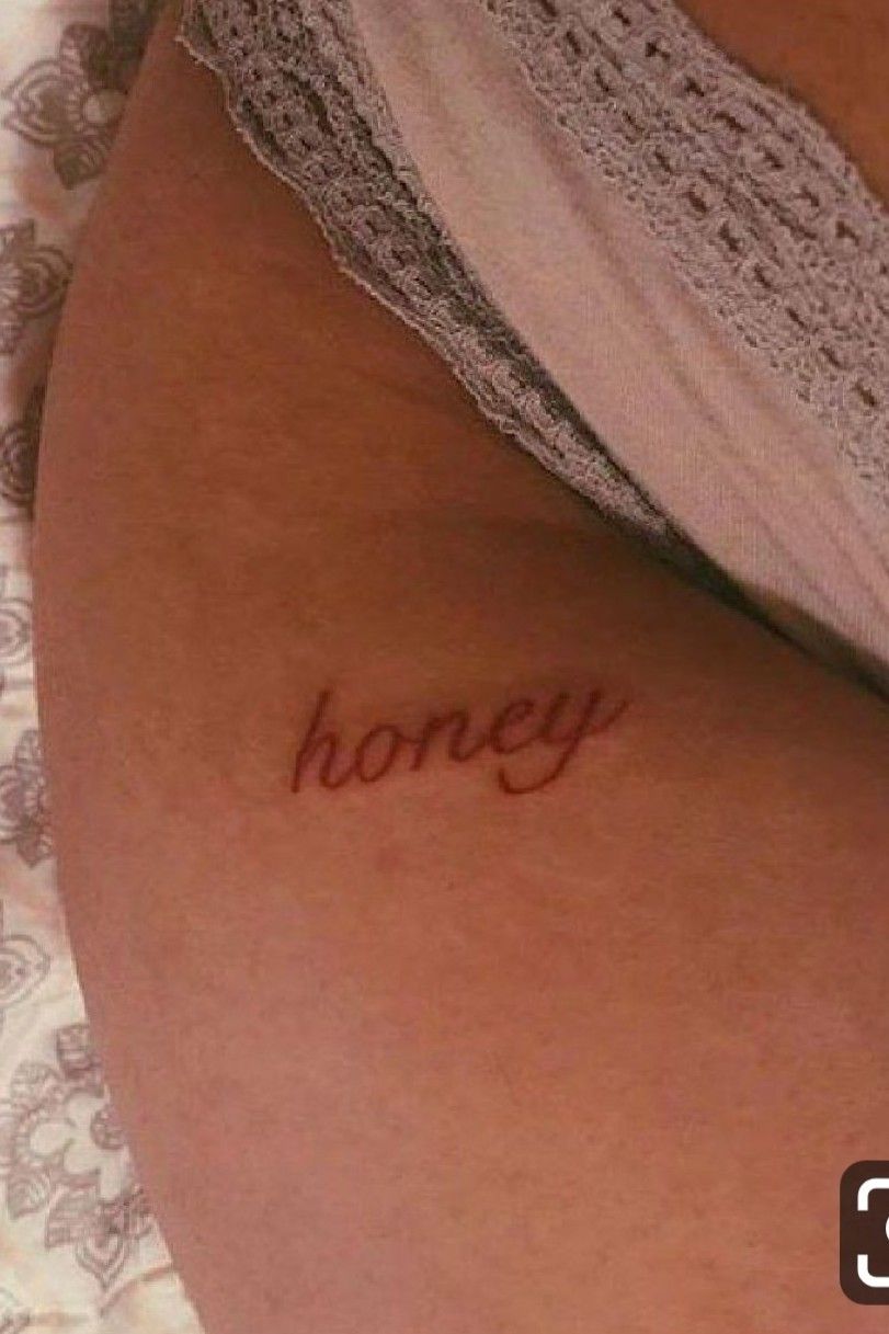 Tattoo of the word honey handwritten on the pelvis