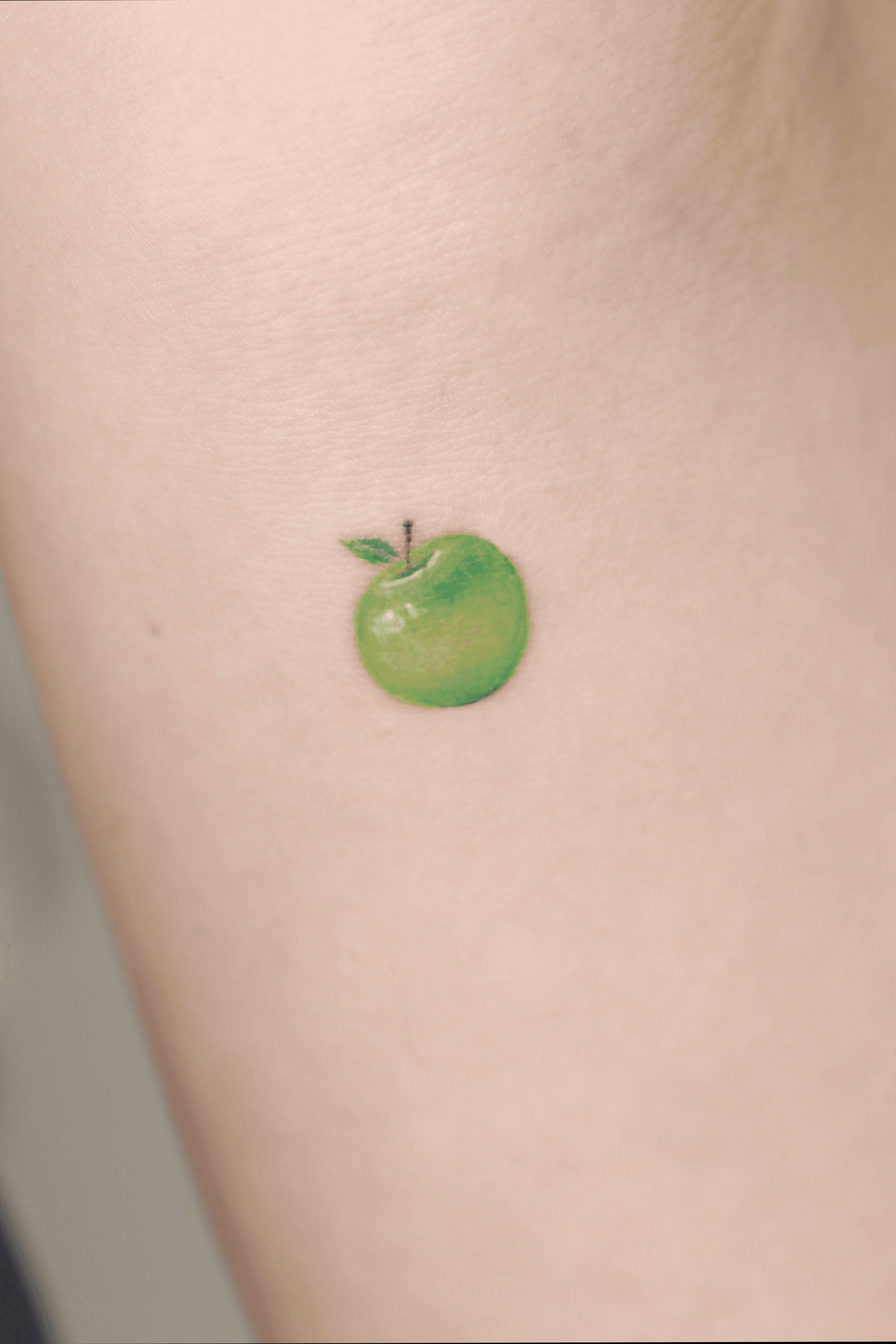 Small apple tattoo on the wrist