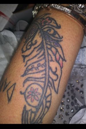 Tribal feather on forearm with hints of color to make it pop.