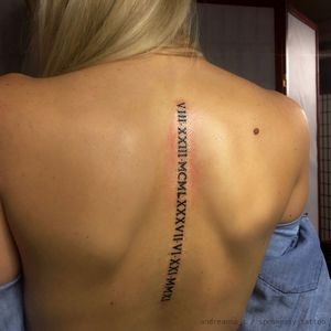 Roman numerals. Women’s back, spine tattoo. #romannumerals #spine #delicate #feminine #linework #smalltattoo #clean #simple #backtattoo #lettering #blackwork 