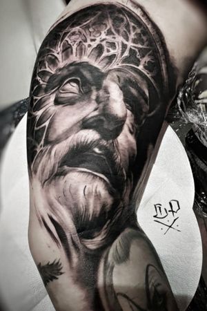 Get mesmerized with Mauro Imperatori's black and gray upper arm tattoo featuring a realistic man pattern design.