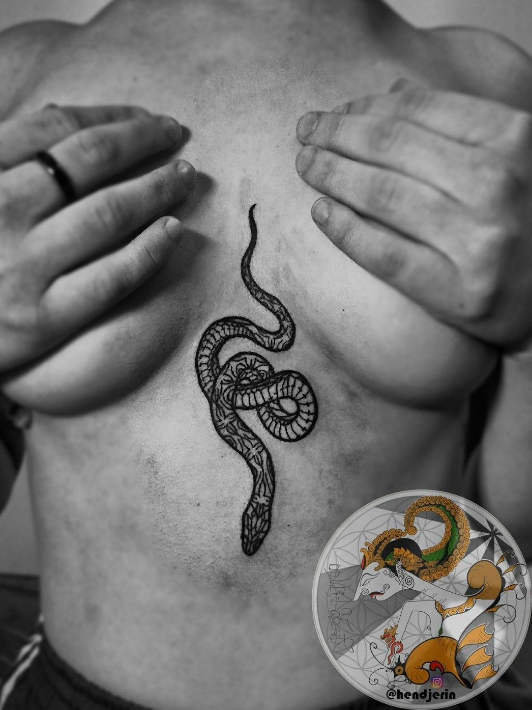 Fine line snake tattoo on the sternum
