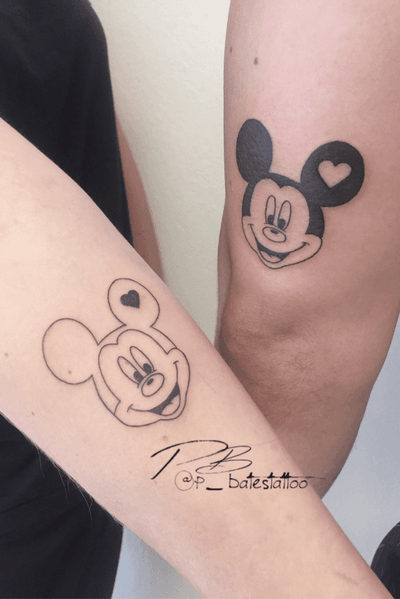 Get a unique blackwork and fine line tattoo of Mickey Mouse inside a heart on your forearm by artist Patrick Bates.