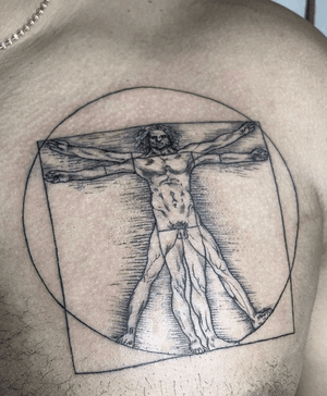 Elegant black and gray fine line illustration of the Vitruvian Man, expertly done by Alejandro Gonzalez on the chest.