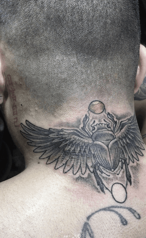 Discover the intricate beauty of a beetle with wings in this stunning black & gray neck tattoo by Alejandro Gonzalez.