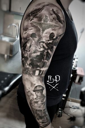 Impressive black and gray upper arm tattoo featuring a soldier and airplanes, done by Mauro Imperatori.