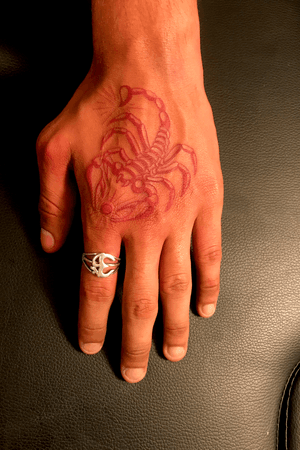 Red scorpion hand tattoo