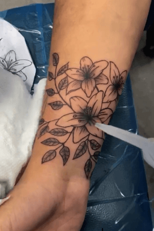 Lily tattoos with leaves wrapping around 