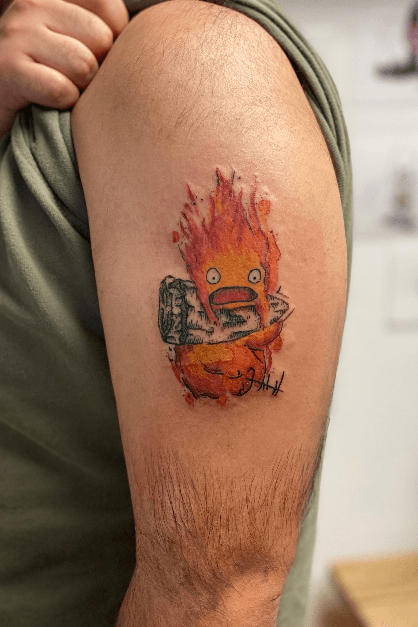 Howls Moving Castle tattoo located on the tricep