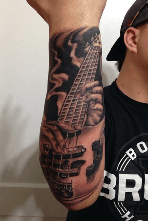 Black and gray bass guitar on outer fore arm...enjoy!
