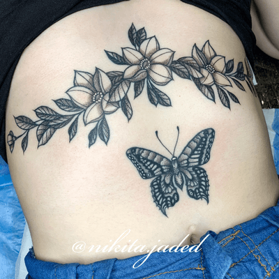 Floral sternum tattoo and butterfly above the naval