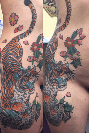 Tiger tattoo on females front with cherry blossoms rocks and water 