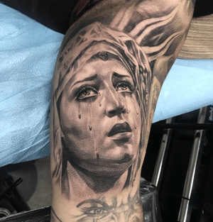 Beautiful black and gray tattoo of a woman shedding tears, on the upper arm, by tattoo artist Jake Masri.